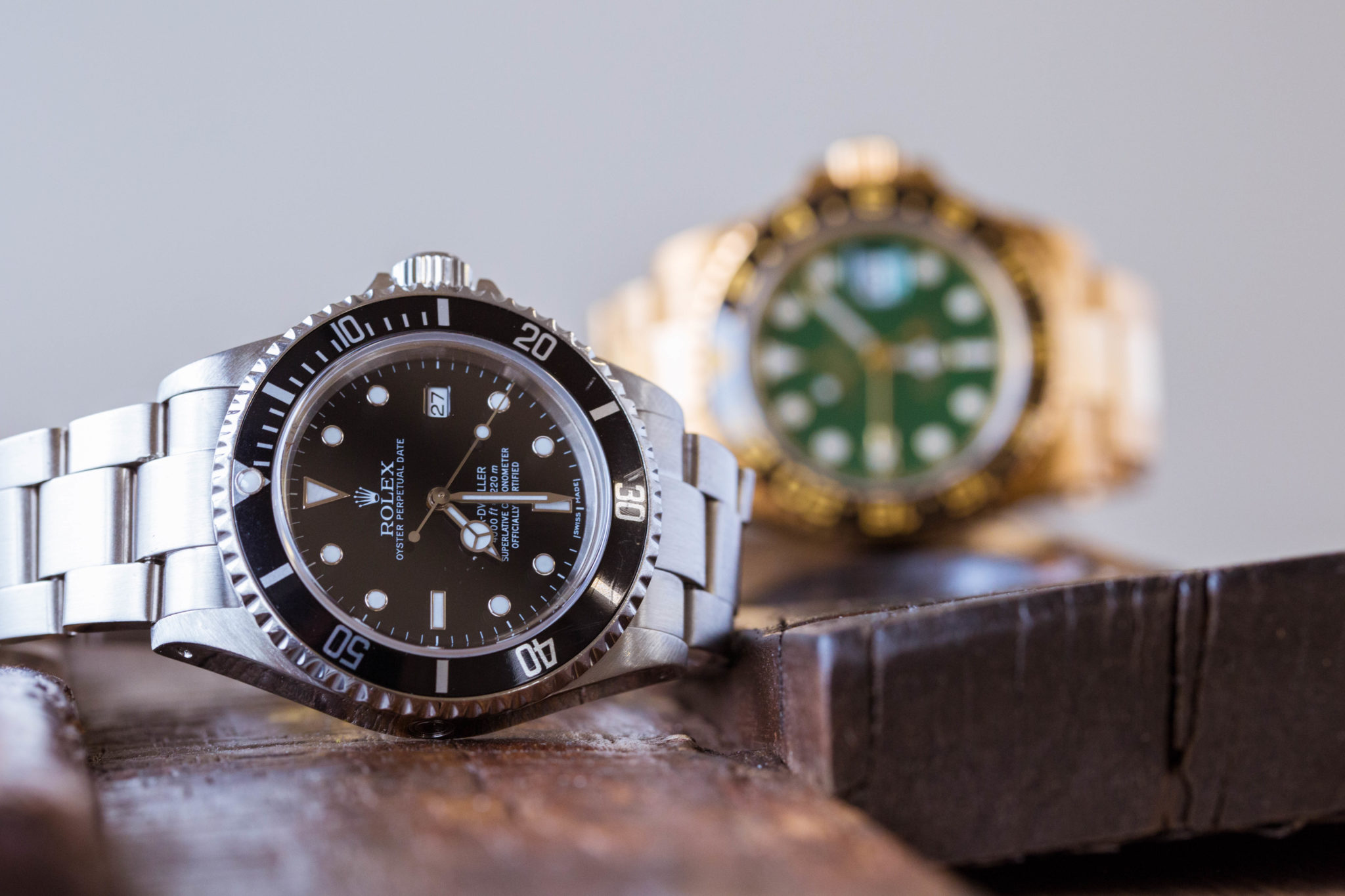 an image of a pair of sea dwellers in white gold and gold sitting on top of wood