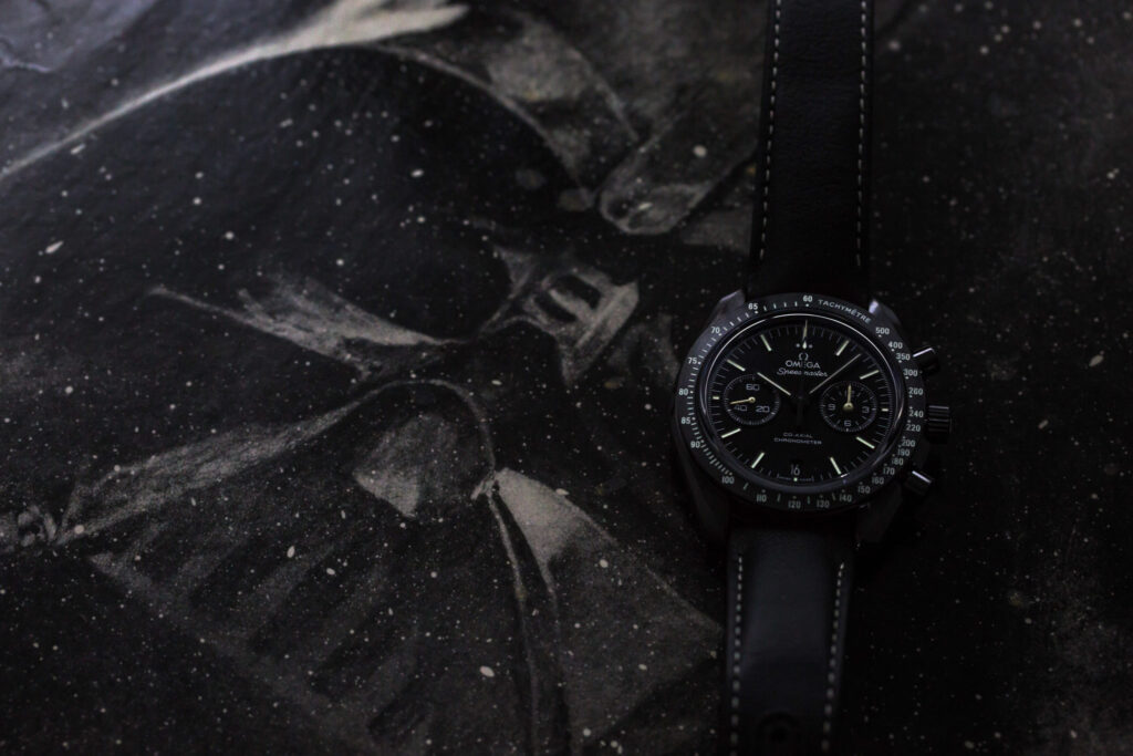 An image of Darth Vader's face with an Omega Dark Side of the Moon watch 