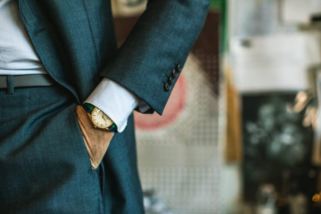 An image of a zenith watch peeking out from under a shirt cuff 