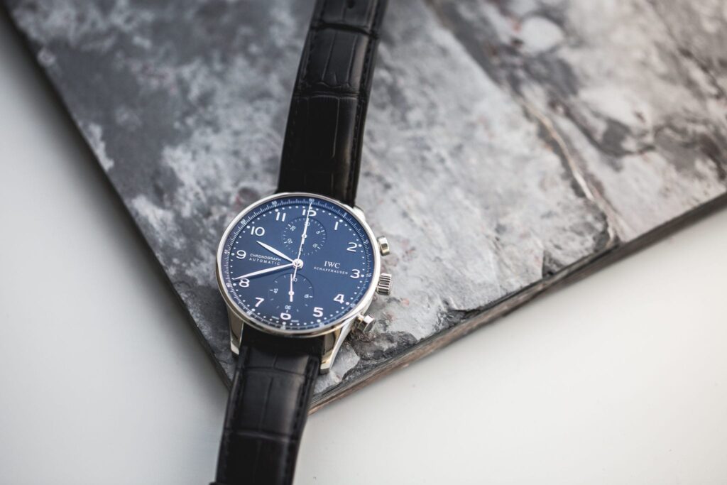 IWC Portuguese and Portofino - A Portuguese with a blue dial, steel case, and black leather band