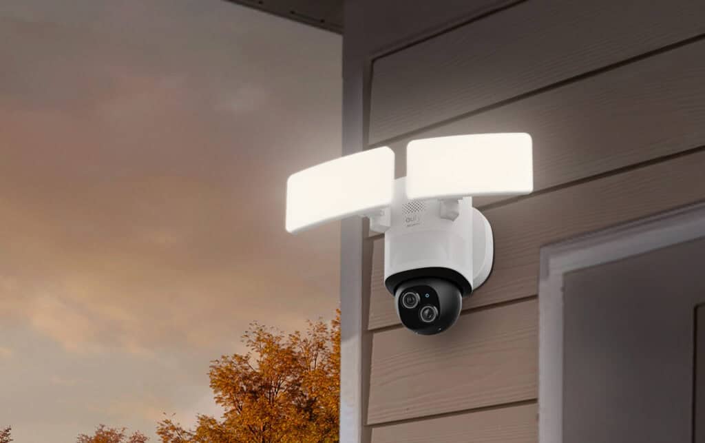 Camera with floodlight on the side of a house.