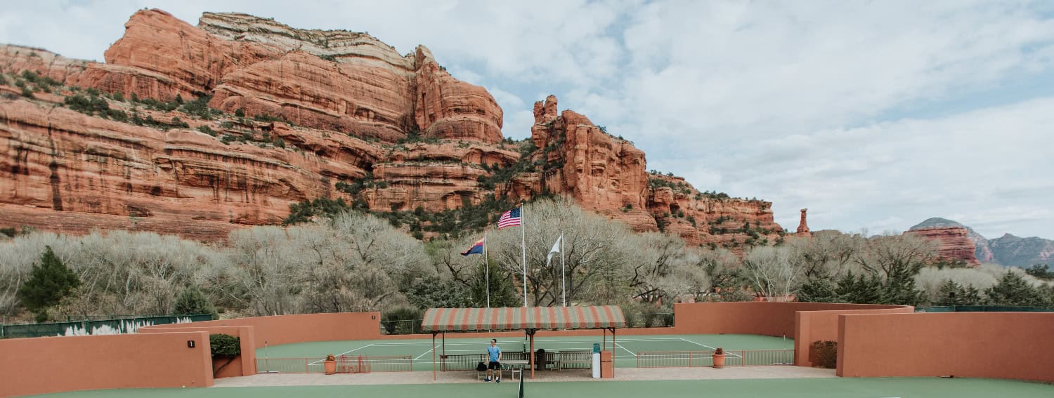 Tennis courts in front of red desert rocks