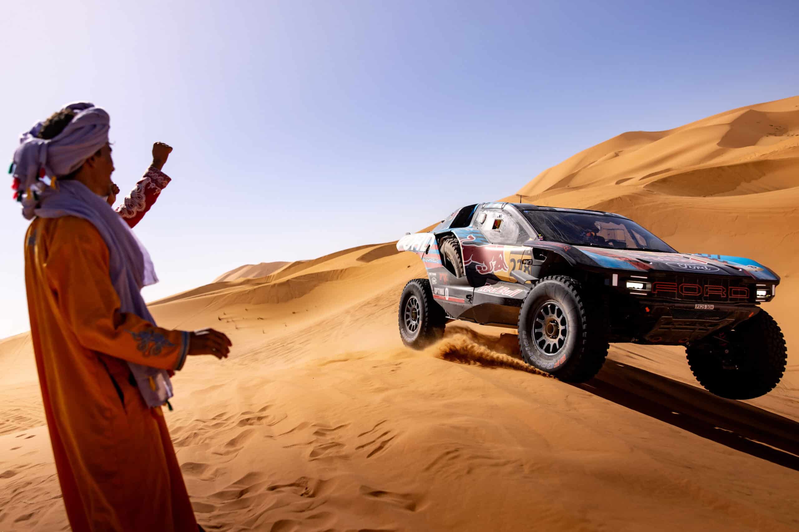 Man cheering car passing him on the dune