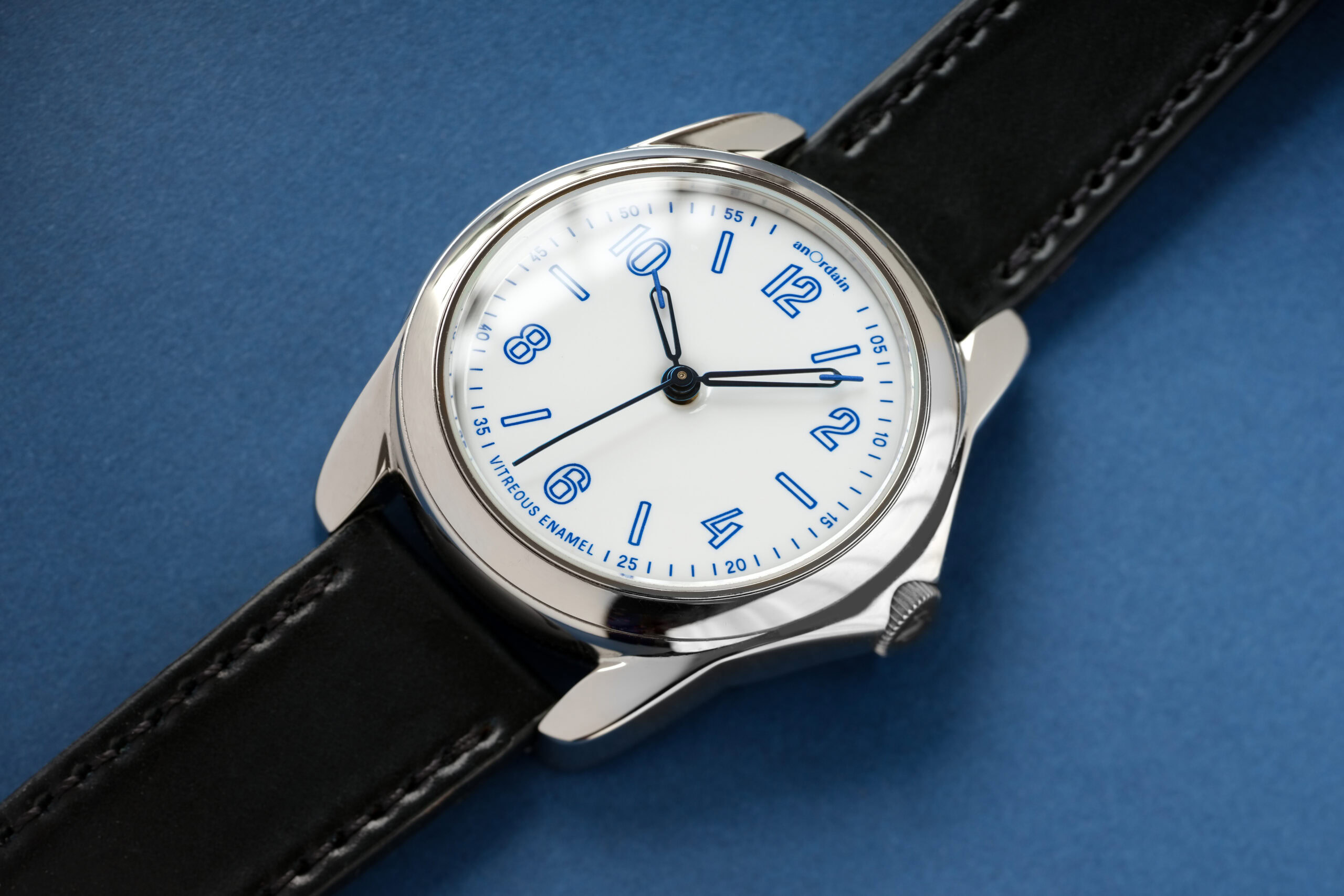 Luxury wristwatch with white face and black leather band for men.